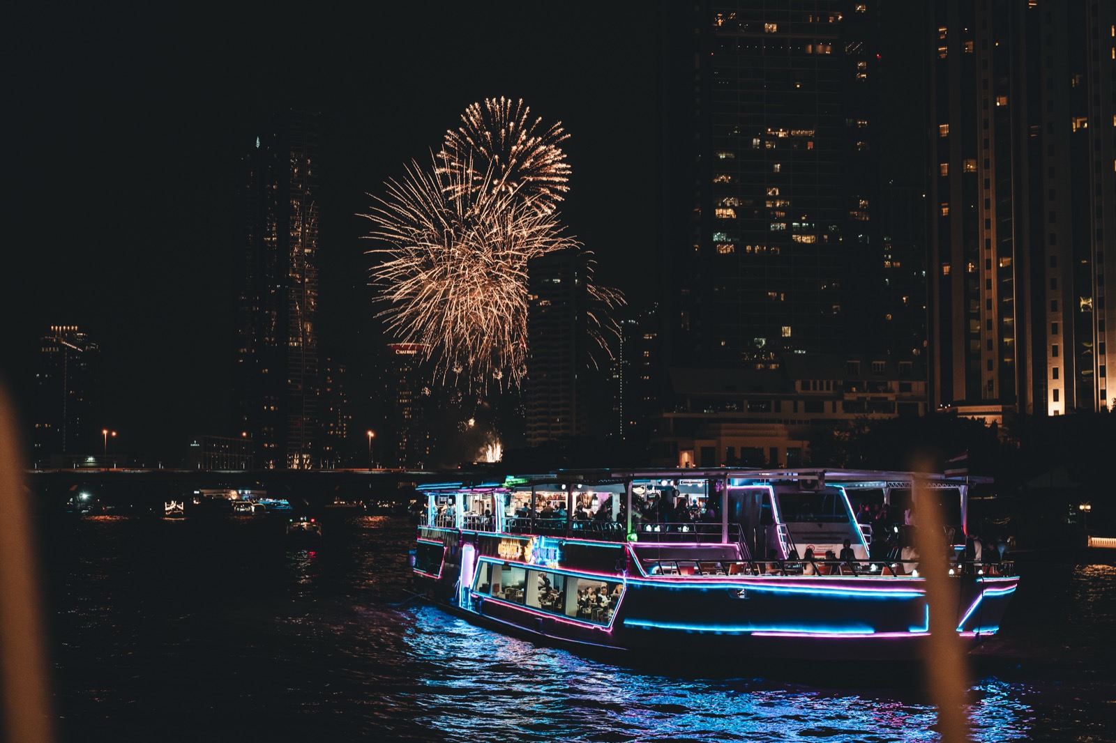 A drone light show and fireworks over the Chao Phraya at night
