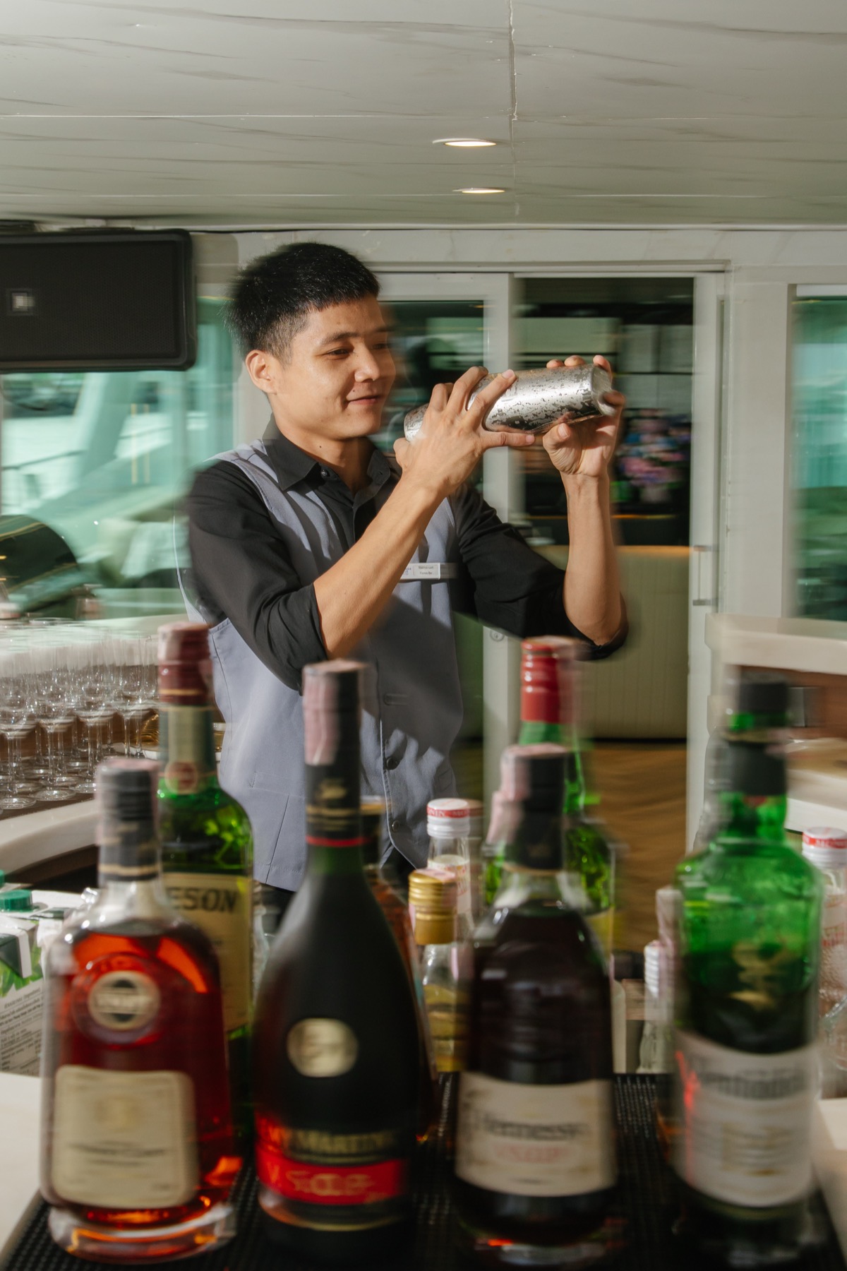 The bar aboard The Legacy Yacht: a lit marble counter and stools, drinks against the skyline